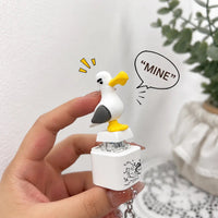 White seagull sound keychain held in a hand