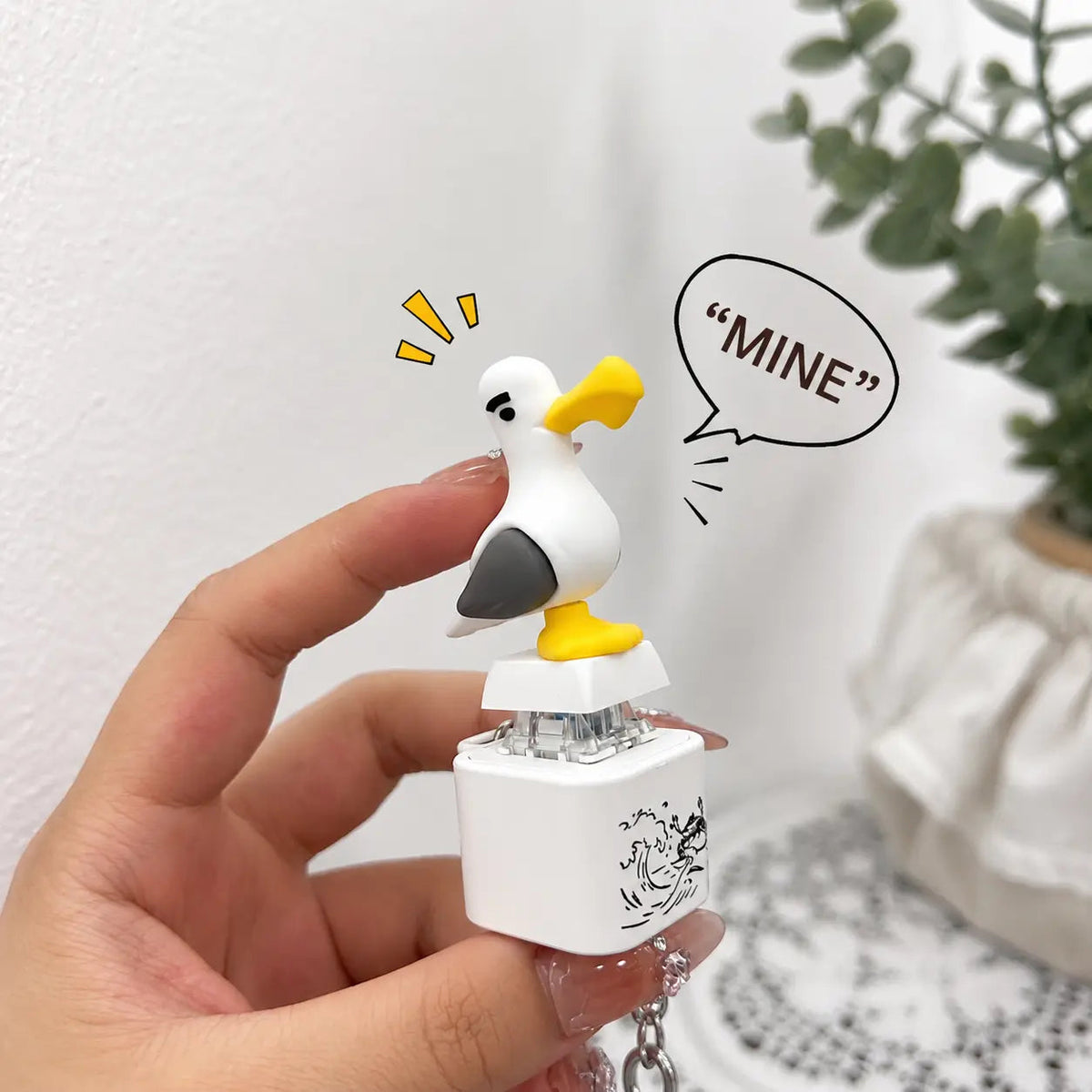 White seagull sound keychain held in a hand