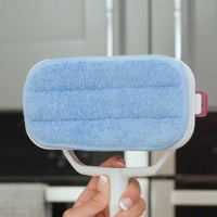 A blue rectangular pad fitted to the white underside of the scrubber head.
