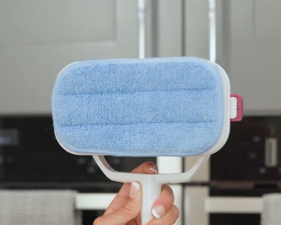 A blue rectangular pad fitted to the white underside of the scrubber head.